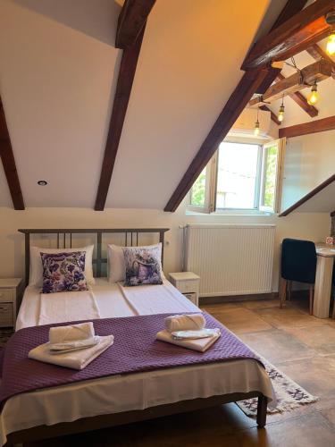 a bedroom with a bed with two towels on it at Apartments PKT DeLux in Niš