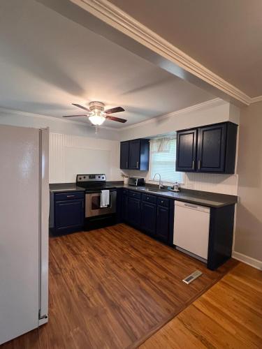 a kitchen with black cabinets and a ceiling fan at Cozy Stay Near DT with Deck and Yard in Winston-Salem