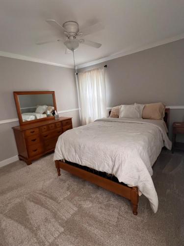 a bedroom with a bed and a dresser and a mirror at Cozy Stay Near DT with Deck and Yard in Winston-Salem