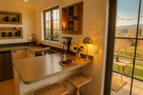 a kitchen with a counter with a table and a window at Shepherds Legacy Hut in Lake Tarawera