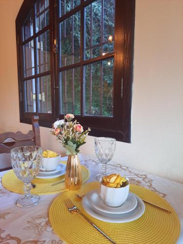 a table with plates and bowls of food on it at Pousada Valle do Sol in Campos do Jordão