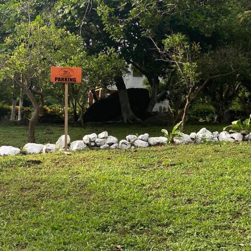 a sign in the grass next to a pile of rocks at Finca Montaña Sagrada in Mérida