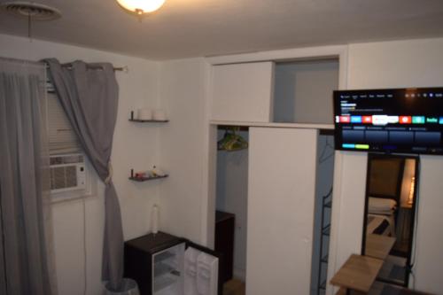 a small room with a kitchen with a television at Miami Drip Star Life Hostel in Parkway Regional Medical Center Heliport