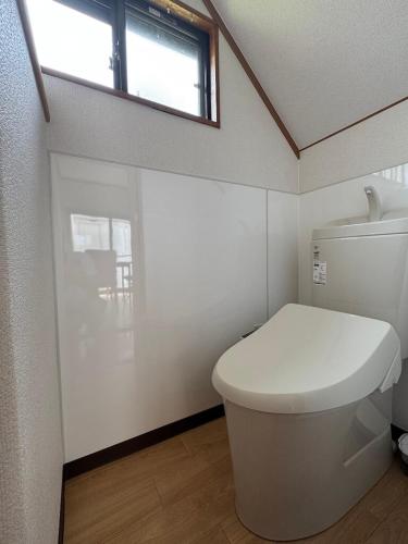 a bathroom with a white toilet and a window at Tokiwaya in Kusatsu