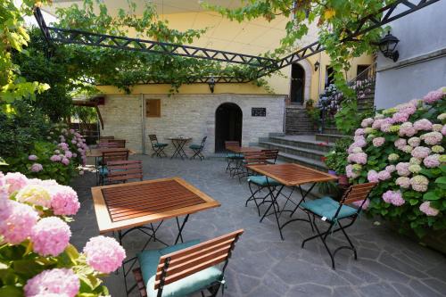 a patio with tables and chairs and flowers at Palorto Traditional Hotel in Gjirokastër