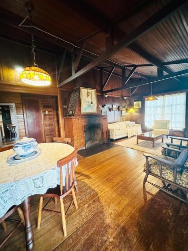 a living room with a table and a fireplace at Chalés Valle do Sol in Campos do Jordão