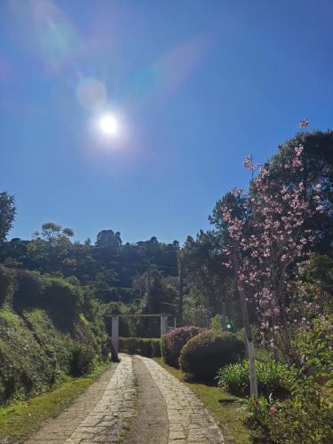 a stone road with the sun in the sky at Chalés Valle do Sol in Campos do Jordão