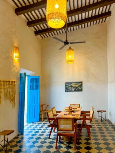 a dining room with a table and chairs and a blue door at Casona Tres Culturas,steps away from the Convent in Izamal