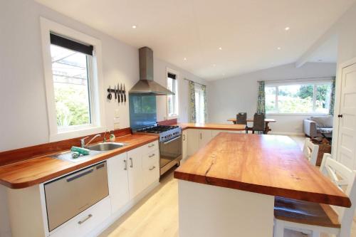 a large kitchen with a wooden counter top in it at Pohara Valley Retreat - Modern & Relaxing Stay in Pohara