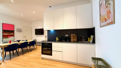 a kitchen with white cabinets and a table and chairs at BeckHomes Munich - Stylish Central Apartments in Munich