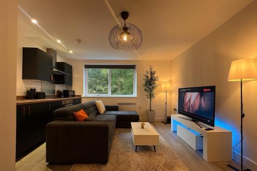 a living room with a couch and a flat screen tv at New York Luxe & Free Onsite Parking in Bradford