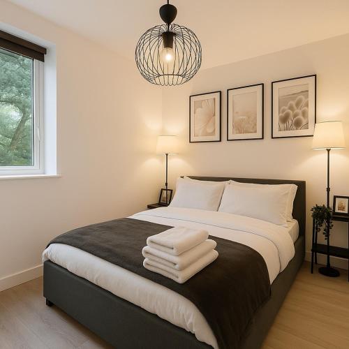 a bedroom with a bed with three towels on it at New York Luxe & Free Onsite Parking in Bradford