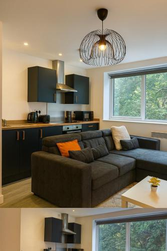 a living room with a brown couch and a kitchen at New York Luxe & Free Onsite Parking in Bradford