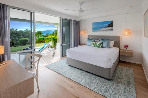 ハミルトン島にあるLagoon Apartments on Hamilton Island by HIHAのベッドとテーブルと机のある寝室