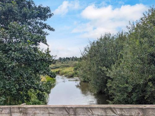 a river with a bridge and trees in the background at 6 person holiday home in Gram in Gram