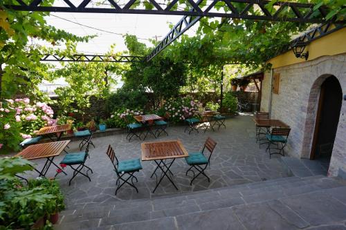 a patio with tables and chairs under a pergola at Palorto Traditional Hotel in Gjirokastër
