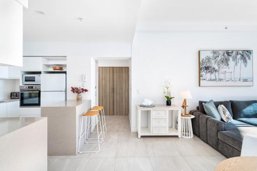 a living room and kitchen with a couch and a table at 'Skyline Oasis' by Inn Paradise in Gold Coast