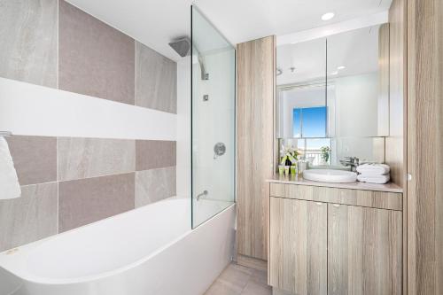 a bathroom with a tub and a sink and a shower at 'Skyline Oasis' by Inn Paradise in Gold Coast