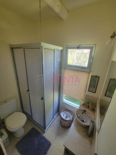un baño con inodoro y lavabo en El Carolino, a residence meters from the sea, en Balneario Buenos Aires