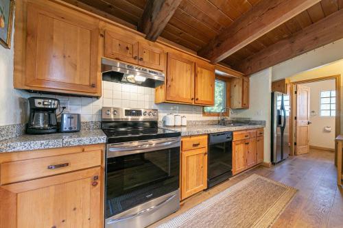 a kitchen with wooden cabinets and a stove top oven at Retreat with Private Hot Tub steps North Lake Tahoe in Carnelian Bay