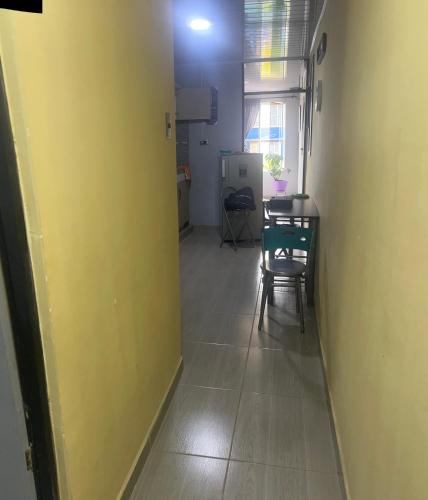 a hallway with a table and chairs and a yellow wall at Acogedor y económico in Bogotá