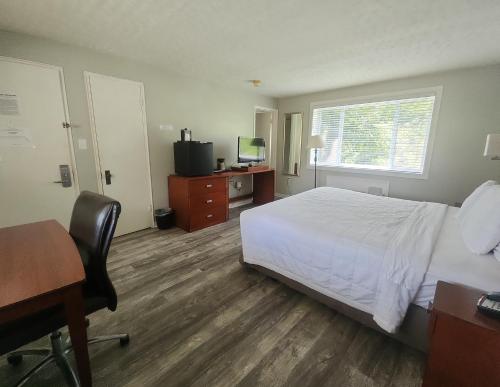 a hotel room with a bed and a desk and a computer at Natural Bridge Hotel, Trademark Collection by Wyndham in Natural Bridge