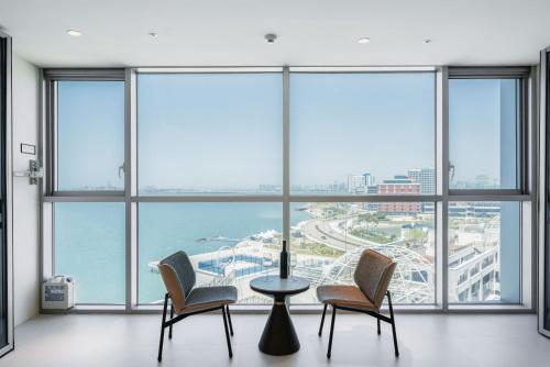 a room with chairs and a table in front of large windows at WAVEM HOTEL west in Siheung
