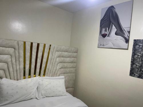 Un dormitorio con una cama y una imagen de una copa de vino. en Las Vegas suites, en Nairobi
