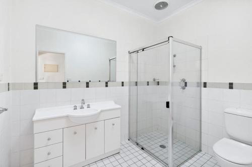 Un baño con ducha, lavabo e inodoro. en Inner North Elegance Premier Turner Living 2 Bed, 2 Bath Townhome, en Turner