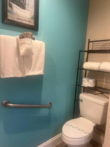 a bathroom with a white toilet and towels at Condo Disney Universal Epic Free Parking in Orlando