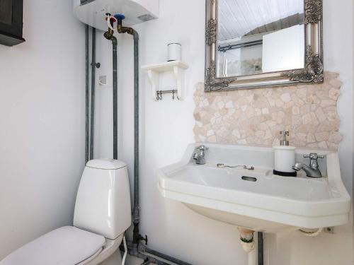 a bathroom with a toilet and a sink and a mirror at 4 person holiday home in Knebel in Knebel