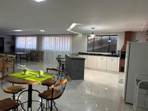 サン・ジョアン・デル・レイにあるApartamento confortável e espaçosoのテーブルと椅子とキッチンのある部屋