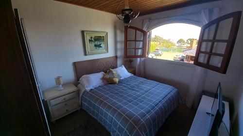 a small bedroom with a bed and a window at Pousada Village Por do Sol by Concavus in Campos do Jordão