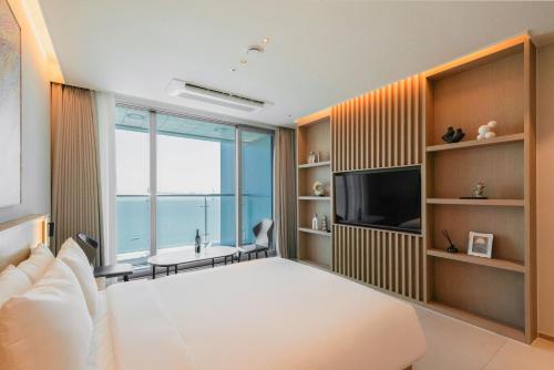 a bedroom with a bed and a view of the ocean at WAVEM HOTEL west in Siheung