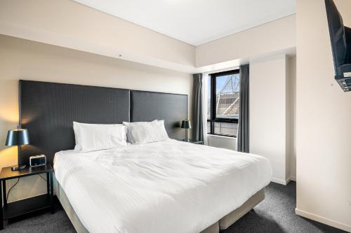 a bedroom with a large white bed and a window at Spacious Apartment in Heart of Southbank in Melbourne