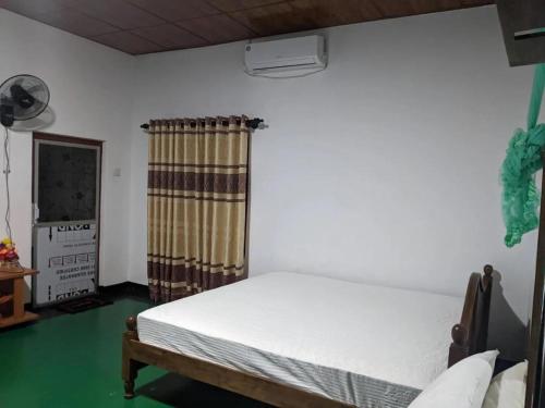 a bedroom with a white bed and a window at Walawwa Resort Kurunegala in Kurunegala