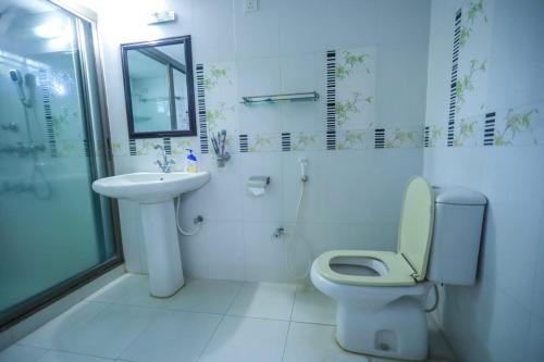 a bathroom with a toilet and a sink and a shower at Sylvan Premium Guest House in Sylhet