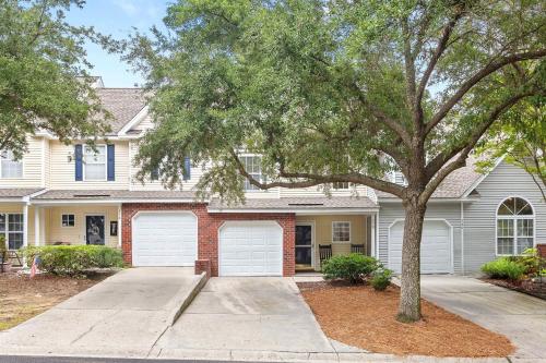 een huis met twee garagedeuren en een boom bij Queen Kelsey - mins from Credit One - pet friendly in Charleston