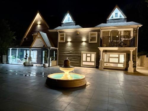 a house with a fountain in front of it at night at Bluebell House in Roydon
