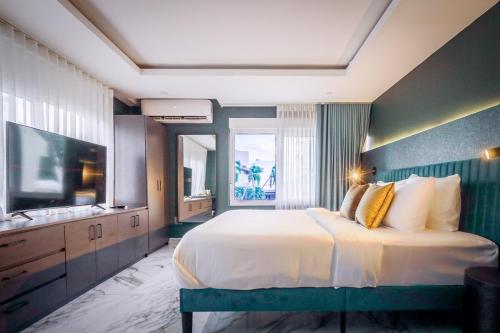 La Victoria King Suite - Kitchen Resort Vibe Near Beach في سان خوان: غرفة نوم بها سرير كبير وتلفزيون