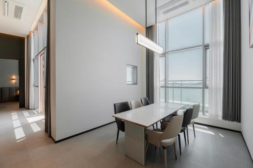 a dining room with a table and chairs and a large window at WAVEM HOTEL west in Siheung