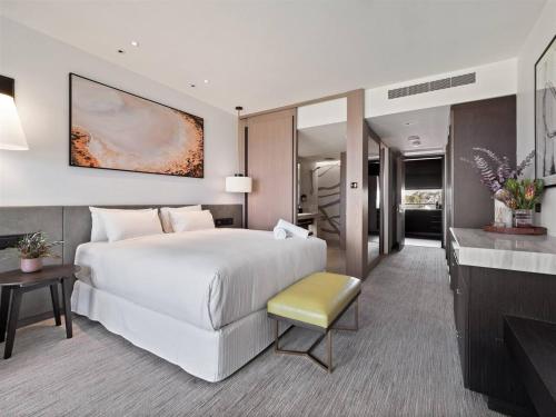 a bedroom with a large white bed and a living room at Samphire Chalet Banksia - A Serene Natural Beauty in Geographe