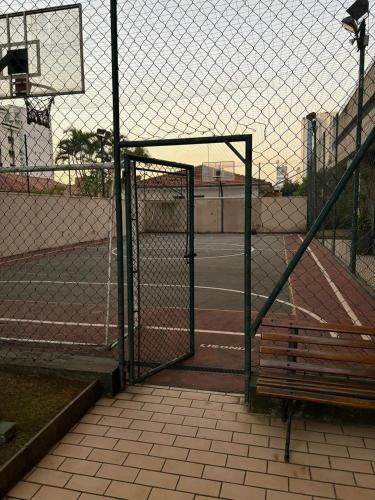 a fence with a bench in front of a basketball court at Hotel Aeroporto Congonhas com cozinha e sacada 1108 S in Sao Paulo