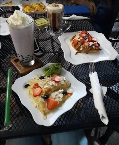 a table with two plates of food and a drink at Hermoso Loft frente a Plaza Mayor en León Gto in Miravalle