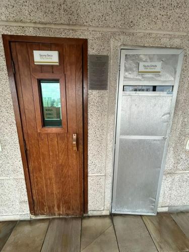 a wooden door in a building with a window at Hotel Aeroporto Congonhas com cozinha e sacada 1108 S in Sao Paulo