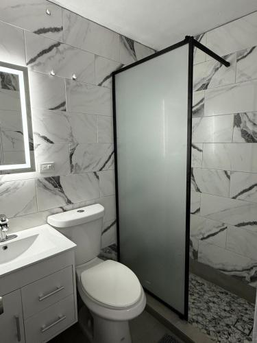 a bathroom with a toilet and a sink and a shower at sleep & go apartment in Las Piedras