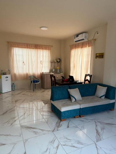 a living room with a blue couch and a table at Hospedaje en Limoncocha in Limoncocha