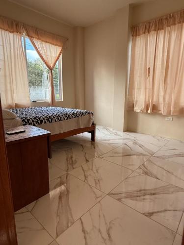 a bedroom with a bed and a marble floor at Hospedaje en Limoncocha in Limoncocha