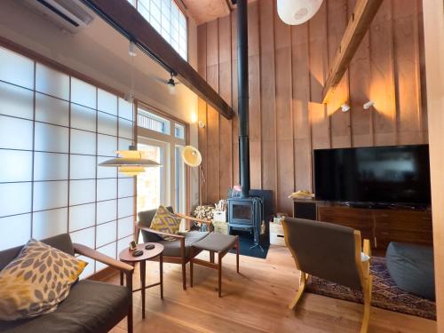 a living room with a couch and a tv at The Cozy Nest Matsukawa in Hakodate