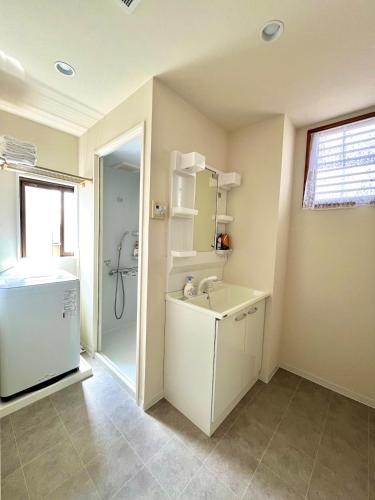 a white bathroom with a sink and a shower at Yotsugi House 3rd Floor - Prime Location Near Asakusa and Skytree in Tokyo